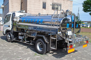 「飲料水」と後部に描かれたシルバーのタンクを積んだ給水車を斜め後方から写した写真