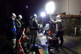 宮城県管工業協同組合が漏水修繕工事において工事箇所をライトで照らしている様子