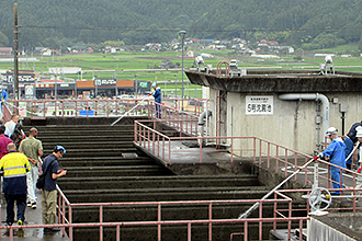 屋外の茂庭浄水場にてコンクリート製の水処理施設を派遣研修員の人々が見学している様子の写真