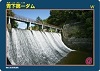 青空に太陽が輝く「青下第一ダム」の放流風景の写真を中心に、左上に名称、右下にロゴマークのある100周年限定ダムカードの写真