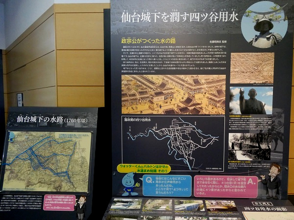 「仙台城下を潤す四ツ谷用水」や「政宗公がつくった水の路」といった解説文、伊達政宗の騎馬像の写真、当時の街並みの絵図や水路図などが詳しく記された展示パネルが壁一面に並んだ写真