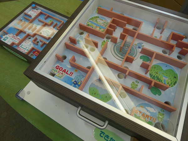 「START!!」から「GOAL!!」までを目指す迷路になっており、水に関連するキャラクターや風景のイラストが描かれた木製枠の大型迷路ゲーム機の写真